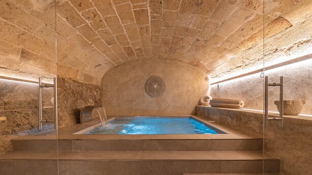 A stone-walled hot tub with steps leading up to it, surrounded by stone walls and a stone bench. - VILA NOVA SUITES & SPA - DOBLE SUPERIOR CON BALCÓN (Capdepera)