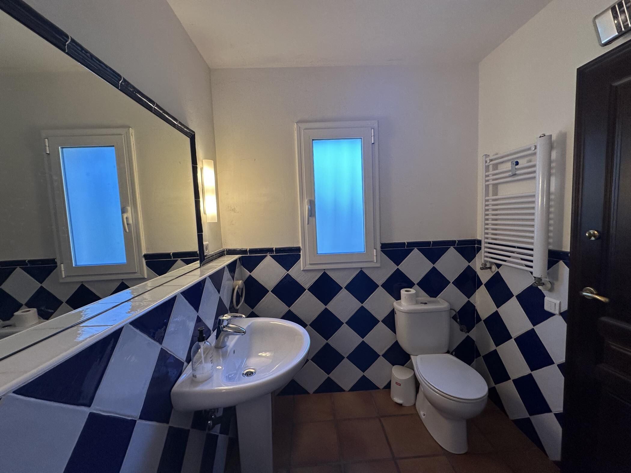 Ein Badezimmer mit Waschbecken, Toilette und Spiegel.