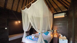 Ein Zimmer mit Himmelbett, Nachttisch und Wandaircondition.