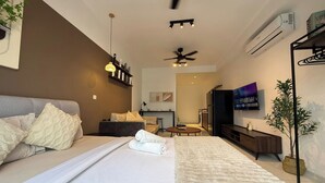 A modern hotel room with a bed, a sofa, a TV, a ceiling fan, and an air conditioning unit. - Majestic Residence Klcc By Luxe (Kuala Lumpur)