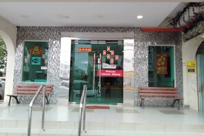 A building entrance with a glass door, a red welcome sign, and two benches outside. -  Sun Tree Hotel @ Triang (Teriang)