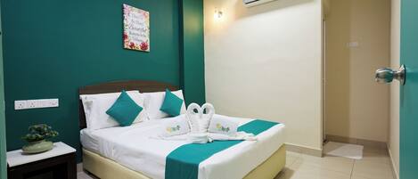 A hotel room with a bed, a nightstand, a wall-mounted air conditioner, and a door.