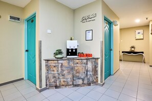 A reception area with a stone counter, teal doors, and a wall-mounted sign.
