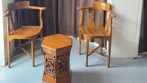 A room with two wooden chairs and a small table, a curtain, and a framed picture on the wall. - Sun Tree Hotel @ Triang (Teriang)