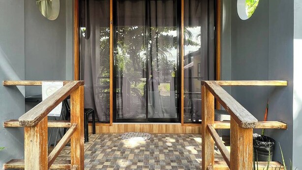 A building entrance with a wooden staircase, a checkered floor, and a large glass door. - Shat'S Guesthouse Siargao Near Beach (General Luna)