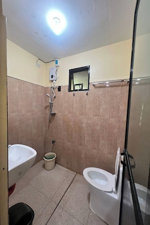 Un baño con ducha, inodoro y lavamanos.