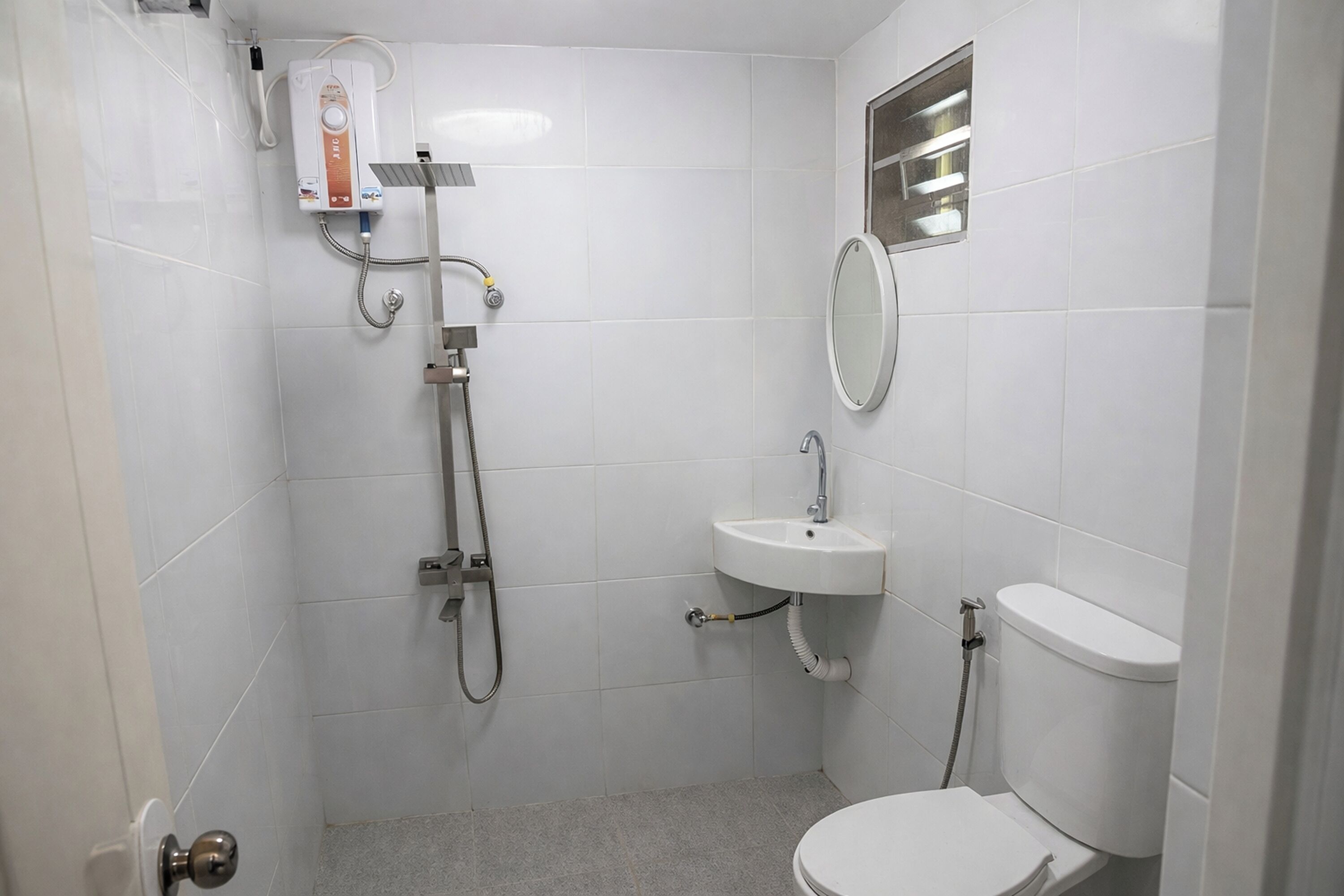 A small, clean bathroom with a toilet, sink, and shower.