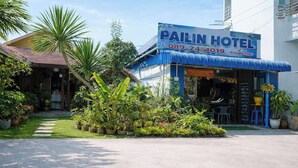 Un hôtel à Pailin avec un auvent bleu et un numéro de téléphone à contacter.