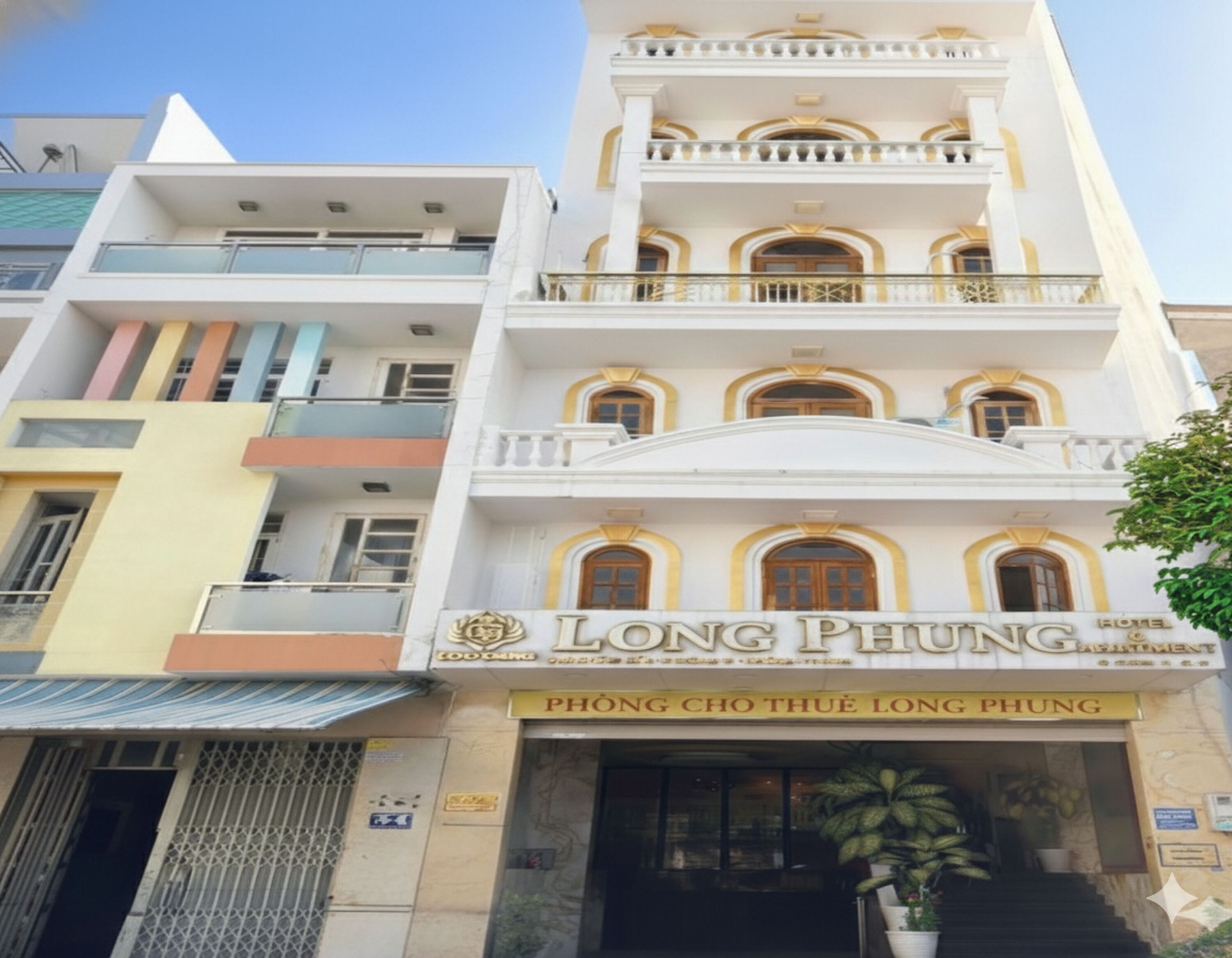 Un hôtel appelé Long Phung, doté d’un style architectural classique, avec de nombreux balcons et une entrée imposante.