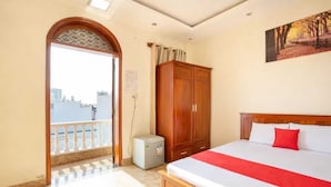 A hotel room with a bed, wardrobe, and a balcony with a city view. - Collection O Long Phung Hotel (Ho Chi Minh City)