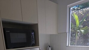 Cocina compacta equipada con microondas, horno y lavavajillas.