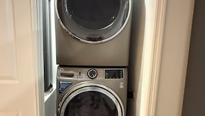 A compact laundry room with two stacked front-loading washing machines.