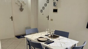 Ein Essbereich mit einem weißen Tisch, blauen Stühlen und einem gefliesten Boden.