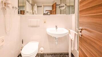 A modern bathroom with a white toilet, a sink, and a mirror.