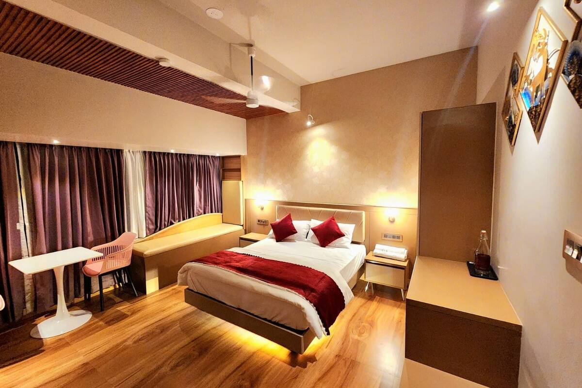 A modern hotel room with a large bed, a desk, and a chair.