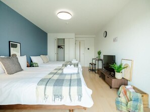 A modern hotel room with a large bed, a TV, a desk, and a wardrobe. - Chuan House Imazato (Osaka)