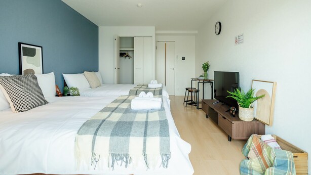 Une chambre d’hôtel moderne équipée d’un grand lit, d’une télévision, d’un bureau et d’une armoire.