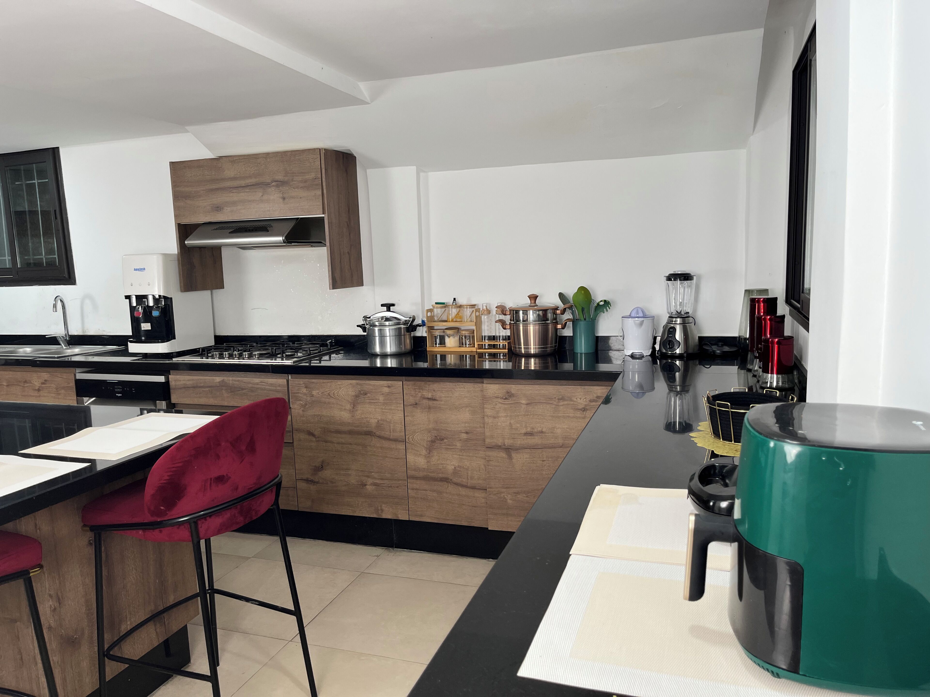 Eine moderne Küche mit Kochinsel, einer Kaffeemaschine und einem Mixer.