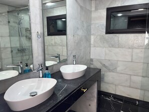 Deluxe villa | Badkamer | Een douche, een haardroger, handdoeken, zeep