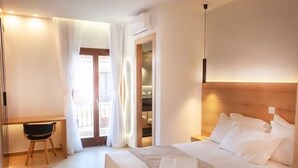 Habitación de hotel con cama, escritorio y vistas al exterior.
