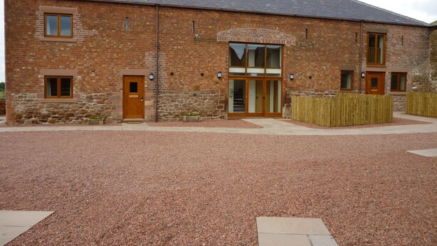 A brick building with a large entrance, a small window, and a door. - Milecastle, Irthington , ideal for couples or families exploring Hadrians Wall (Irthington)