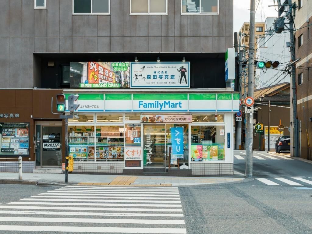 Ein FamilyMart-Geschäft mit großer, klarer Schaufensterfront und einem Fußgängerüberweg davor.