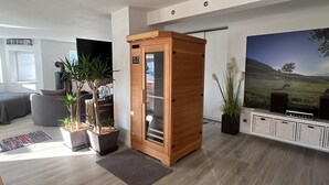Ein modernes Wohnzimmer mit einem Holzschrank, einem Fernseher und einem großen Landschaftsbild.