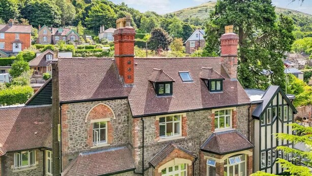 A traditional stone house with multiple chimneys, a sloped roof, and a bay window. - Beautiful 2 Bedroom Apartment in Malvern (Malvern)