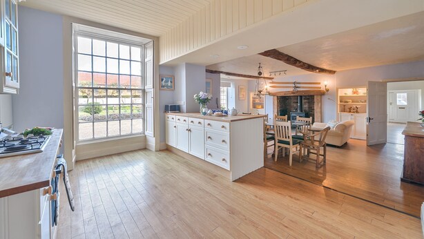 Una cocina amplia con una isla grande, piso de madera y vistas al exterior.