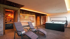 A modern indoor pool area with two lounge chairs and a pool table.