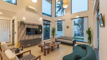 Deluxe villa, balkon, uitzicht op tuin | Woonruimte | Een 55-inch flatscreentelevisie met satellietzenders