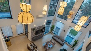 Amplia sala de estar con chimenea, asientos confortables y grandes ventanales con vistas al exterior.