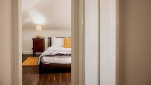 Ein Schlafzimmer mit einem Bett, einem Nachttisch, einer Lampe und einem Teppich.