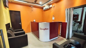 A reception area with a reception desk labeled "Reception," a ceiling fan, and a clock on the wall. - Townhouse Guwahati Airport (Guwahati)