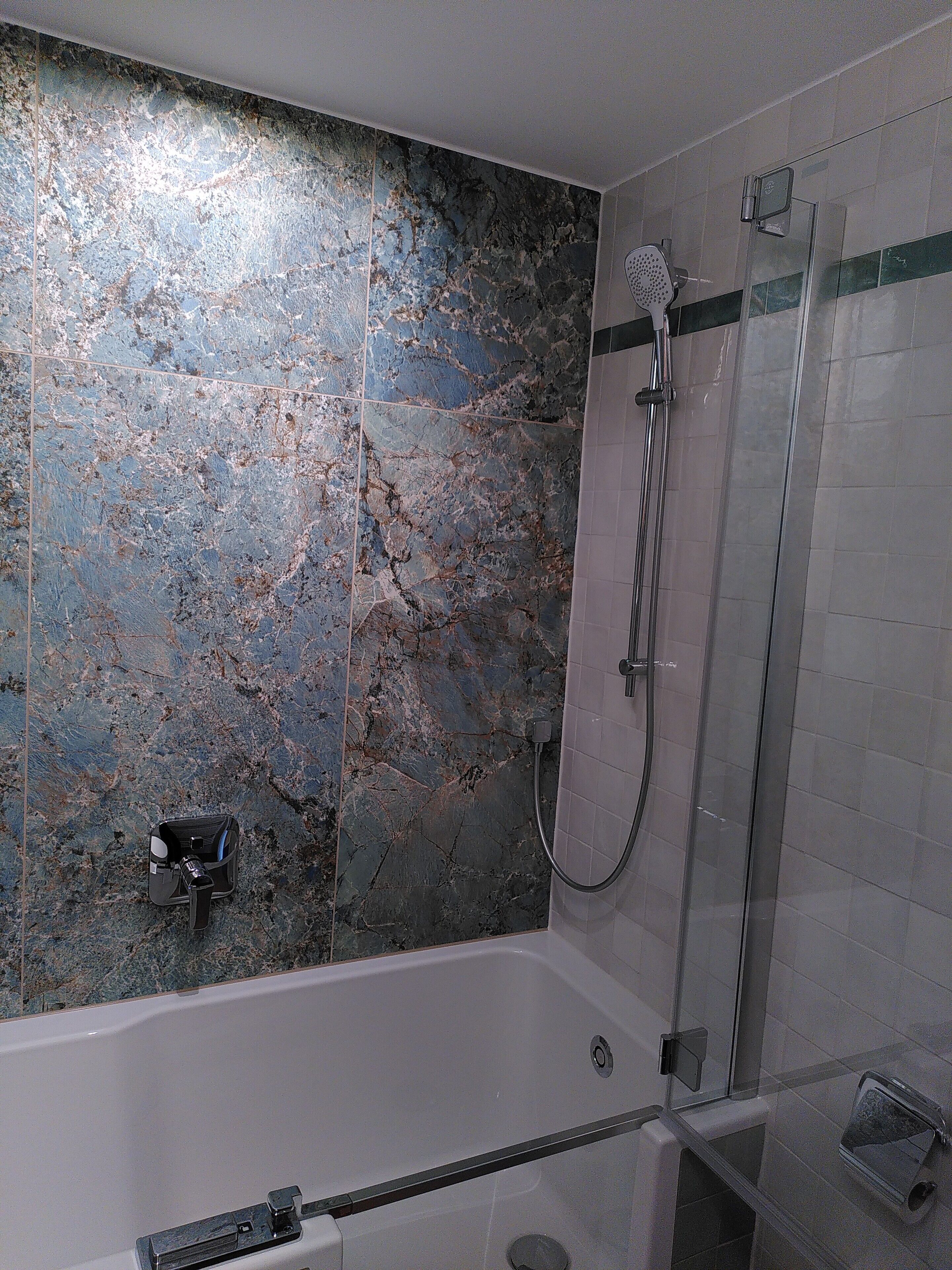 A bathroom with a bathtub, a shower, and a glass-enclosed shower area.