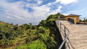 Une propriété située sur la côte, accessible par un chemin de terre qui mène à un bâtiment doté d’un toit en tuiles.