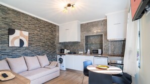 Un appartement moderne comprenant un espace de vie, une kitchenette et un coin repas.