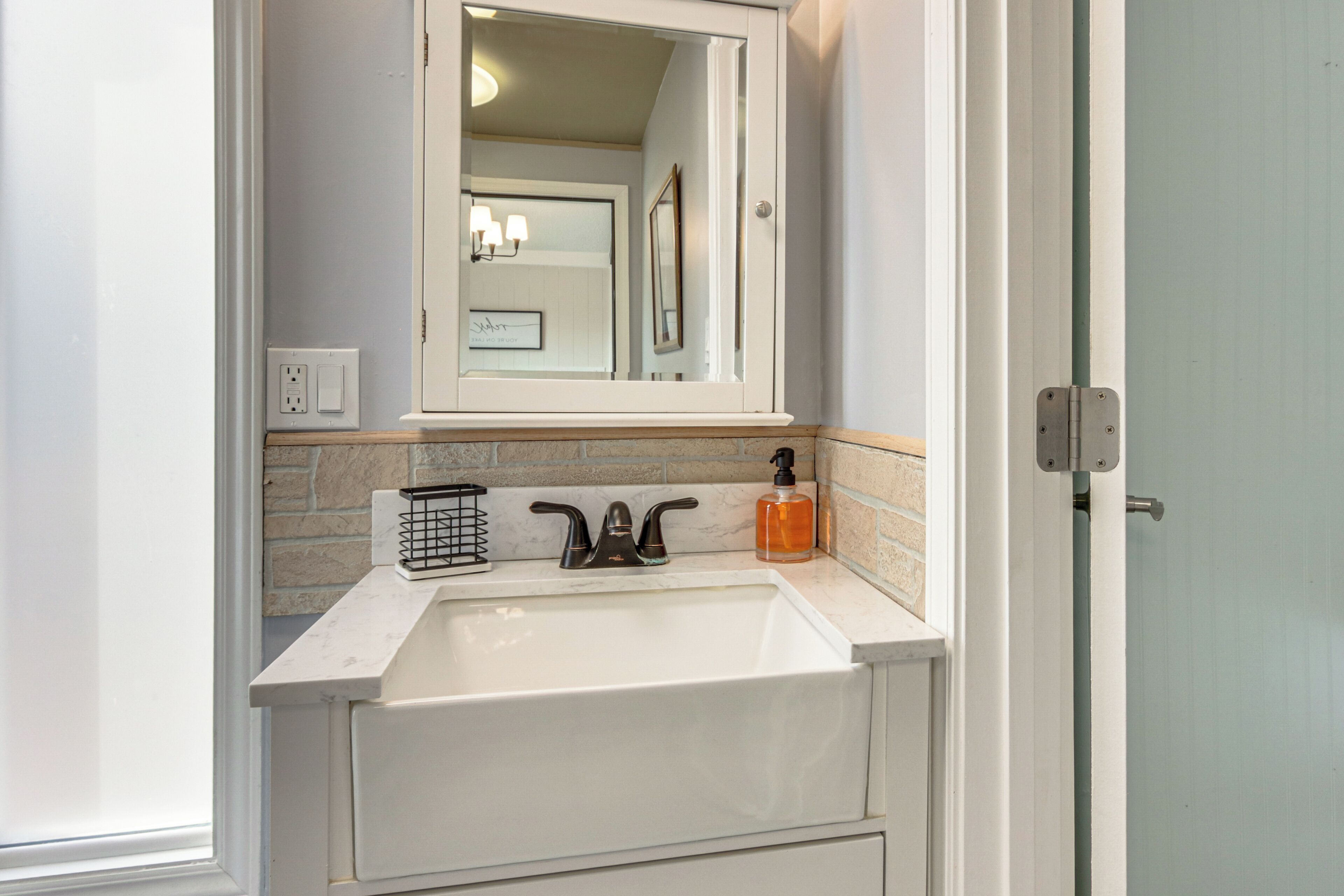 A bathroom with a white sink, a mirror above it, and a towel rack.