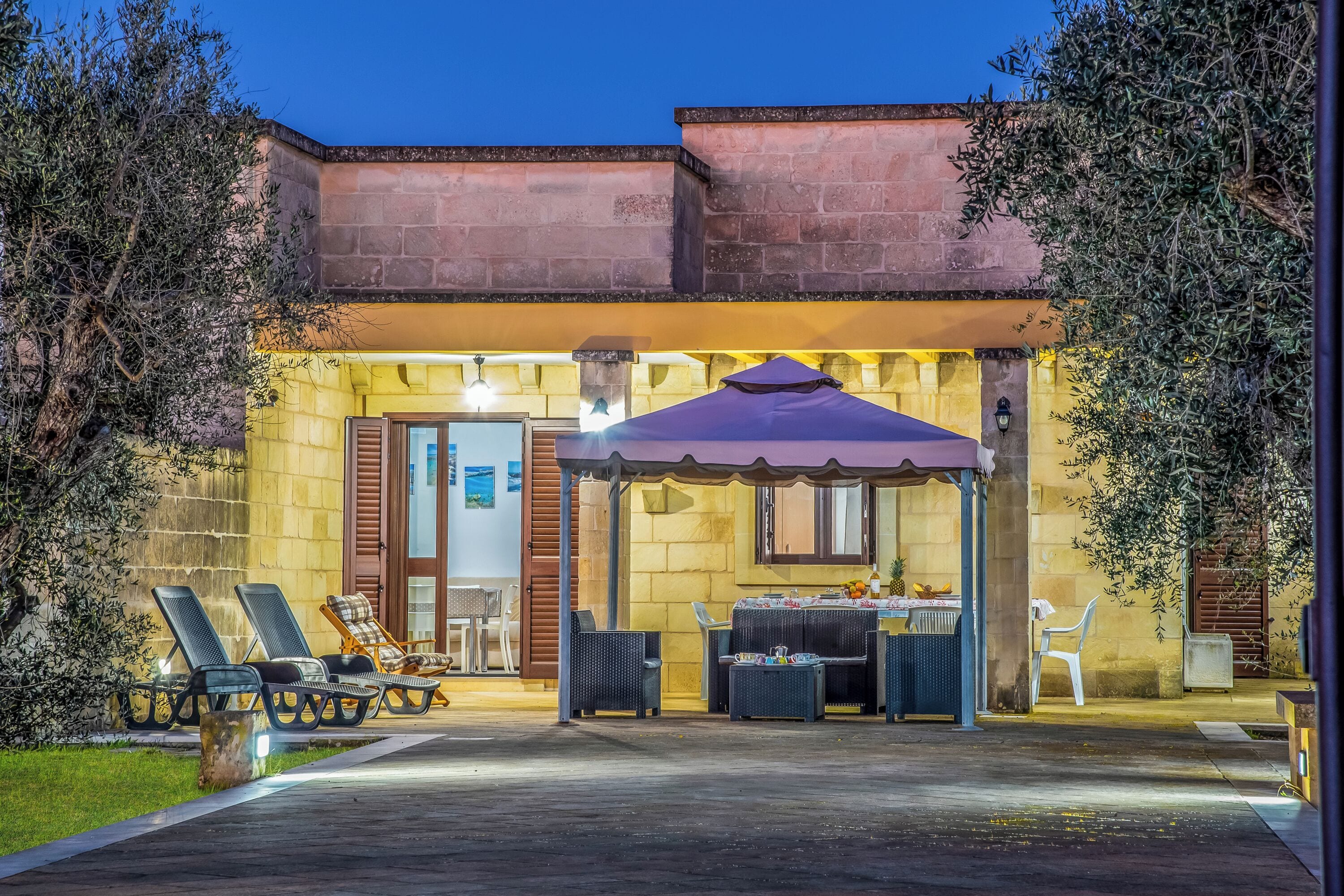 A building with a patio area featuring outdoor seating and a covered table.