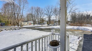 A residential area with a snow-covered driveway, a white railing, and a house in the background. - Pet Friendly & WFH Ready! Quiet Hudson Valley Apt (Newburgh)
