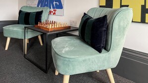 A room with two green armchairs, a chessboard, and a Star Wars poster. - 8 bedroom accommodation in Sunderland (Sunderland)