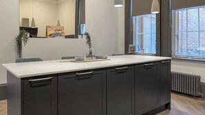 A modern kitchen with a large island, dark cabinetry, and a window providing a view of the city. - 8 bedroom accommodation in Sunderland (Sunderland)