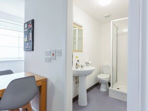 A room with a desk, chair, white walls, a sink, toilet, and a shower. - 21M Wildercombe- UKC8996 (Illfracombe)