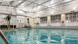 An indoor swimming pool with a clear ceiling structure, safety signs, and a ladder. - 177 Residences - UKC8999 (Illfracombe)