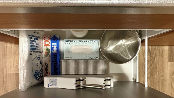 A kitchen counter with a metal pot, a white plastic bag, a blue box labeled 'Paku', and a white appliance. - Solana Smart INN Fuji Yamanakako (Yamanakako)