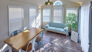 A dining area with a wooden table and chairs, a light blue sofa, and a potted plant. - Solana Smart INN Fuji Yamanakako (Yamanakako)