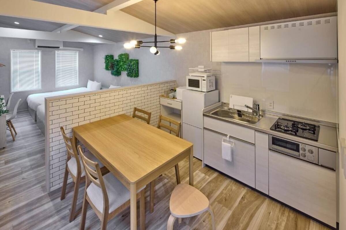 A compact kitchen with a dining area, white cabinets, a microwave, and a gas stove.