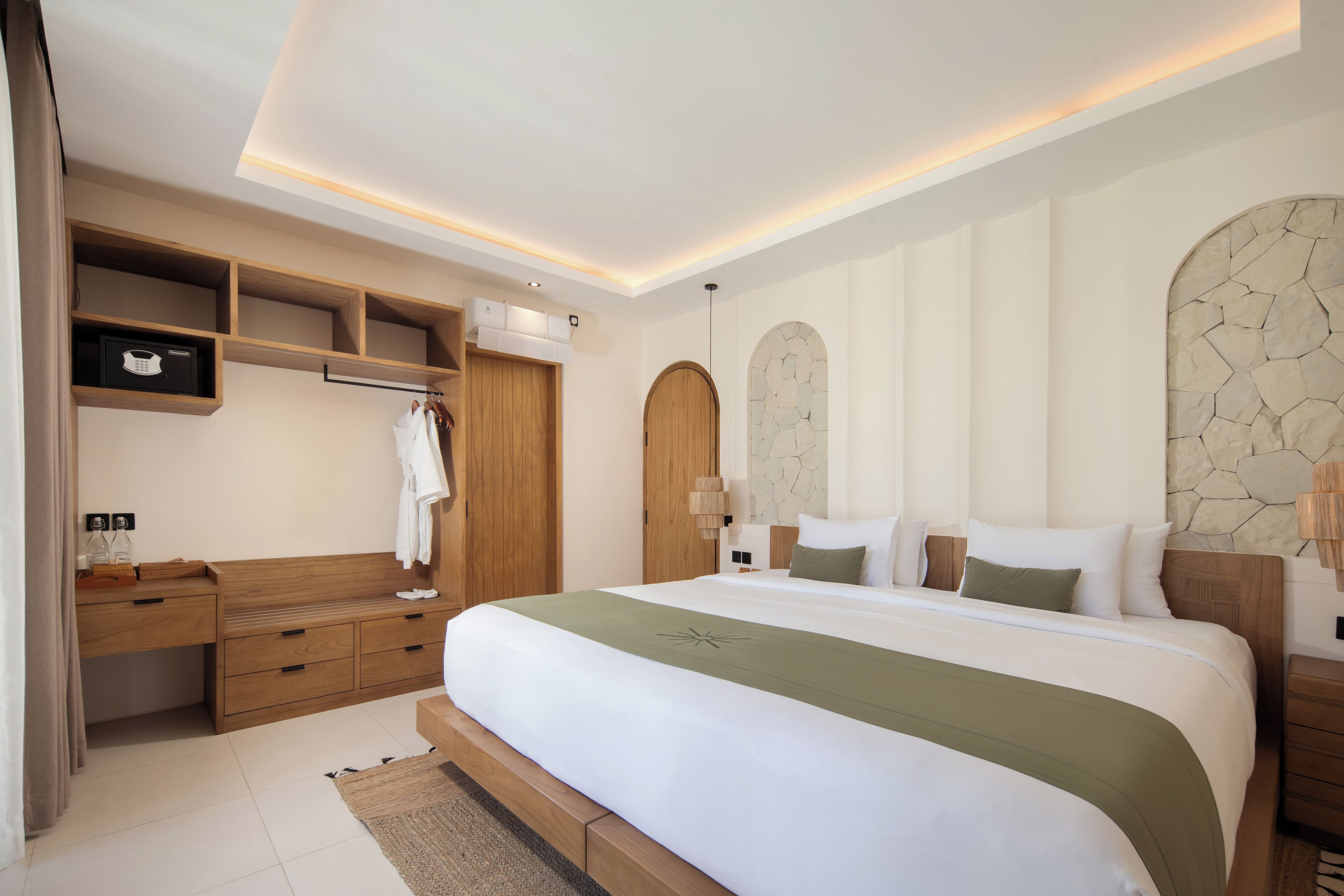 A modern bedroom with a large bed, wooden wardrobe, and built-in shelving.