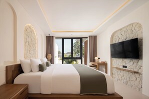 Une chambre d’hôtel moderne dotée d’un grand lit, d’un téléviseur à écran plat fixé au mur et offrant une vue sur l’extérieur par la fenêtre.
