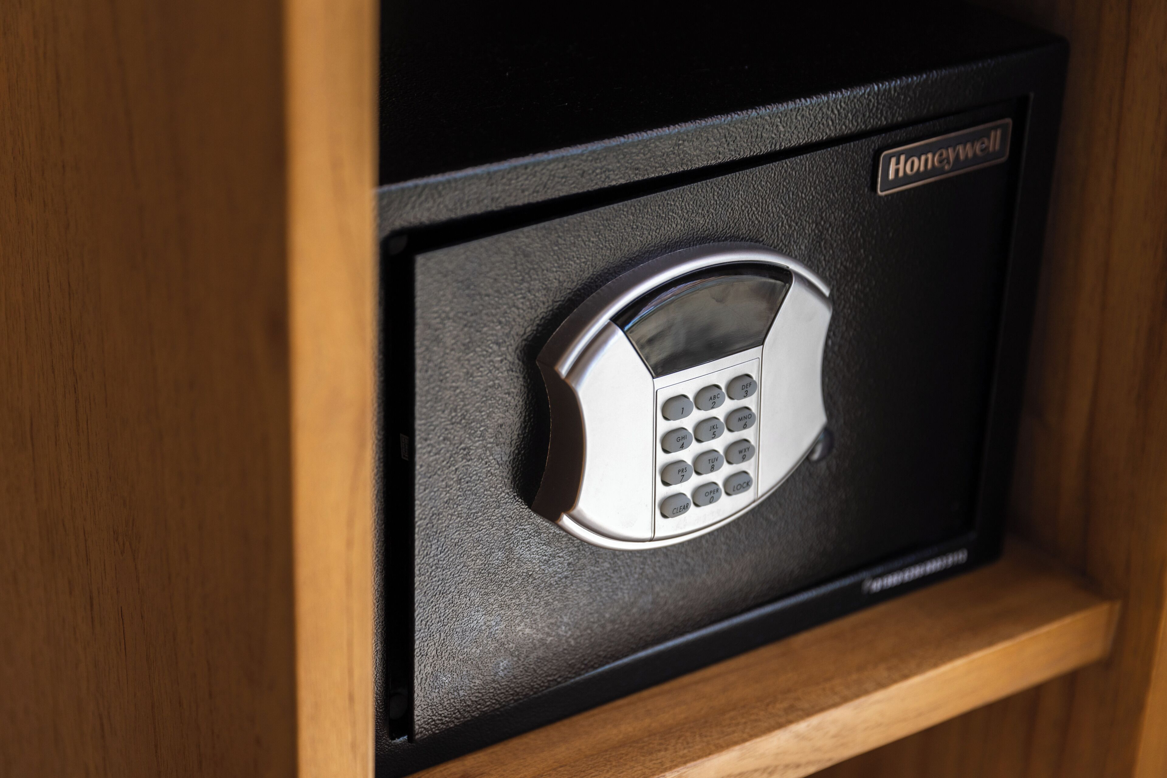 A Honeywell electronic keypad lock on a wooden door.
